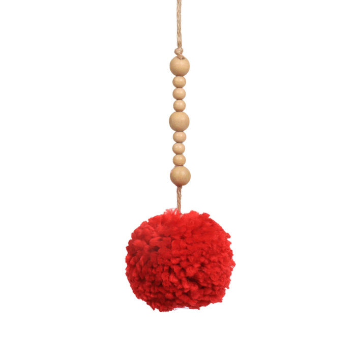 Red pom pom hanging from natural-coloured wooden beads