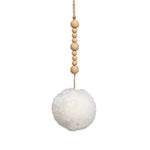 White pom pom hanging from natural-coloured wooden beads