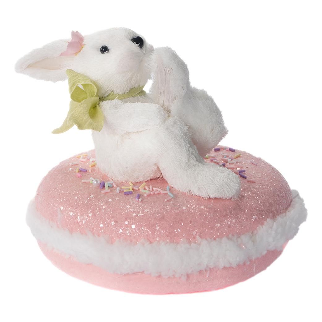 White Easter bunny sat on a pink macaroon 