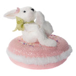 White Easter bunny sat on a pink macaroon 